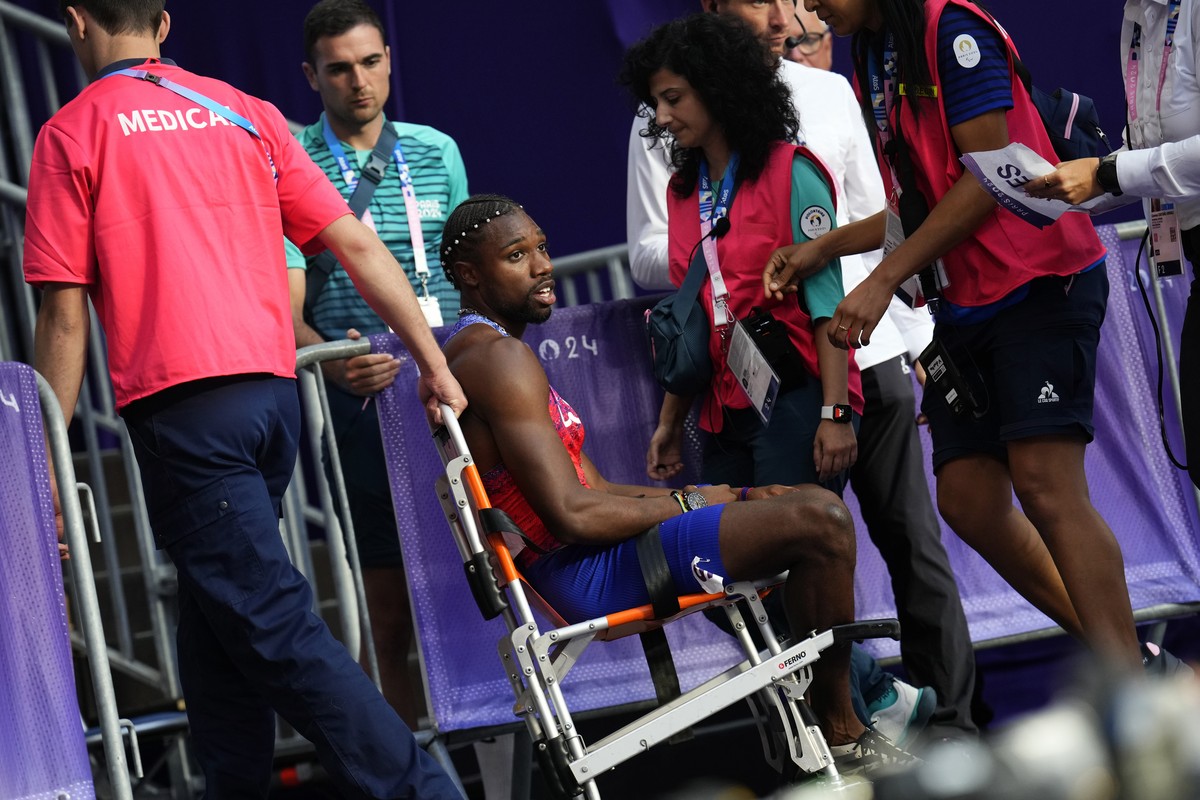 Noah Lyles, of the United States, is taken from the track following the men's 200-meters final at the 2024 Summer Olympics, Thursday, Aug. 8, 2024, in Saint-Denis, France. (AP Photo/Petr David Jo ...