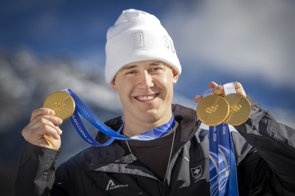 Gold medalist Franjo von Allmen of Switzerland poses for photographers with his three gold medals during a photocall outside the Swiss team hotel at the 2026 Olympic Winter Games at the Stelvio Ski ce ...