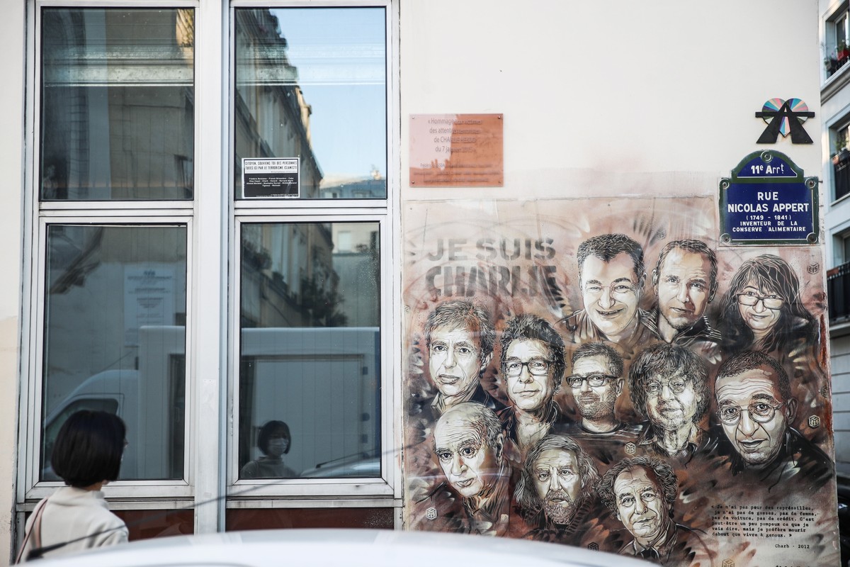epa08640729 A woman looks at a paintings depicting Charlie Hebdo's killed cartoonists by French street artist Christian Guemy, outside the satirical .newspaper Charlie Hebdo's former office, ...