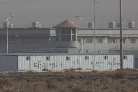 In this Monday, Dec. 3, 2018, photo, a guard tower and barbed wire fences are seen around a facility in the Kunshan Industrial Park in Artux in western China's Xinjiang region. People in touch with st ...