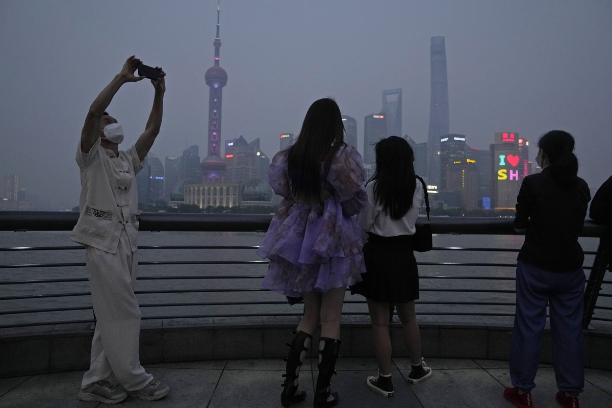 Residents enjoy the view at dusk along the bund, Wednesday, June 1, 2022, in Shanghai. Traffic, pedestrians and joggers reappeared on the streets of Shanghai on Wednesday as China's largest city  ...