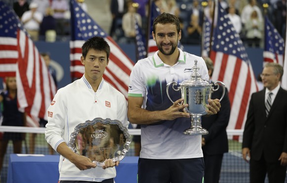 FILE - In this Sept. 8, 2014, file photo, Marin Cilic, of Croatia, right, holds the championship trophy and Kei Nishikori, of Japan, holds the runner-up trophy after Cilic defeated Nishikori in the ch ...