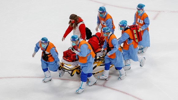 epa09732032 Mengying Zhang of China is brought off the ice rink following an injury during the Women&#039;s Ice Hockey preliminary round match between China and Japan at the Beijing 2022 Olympic Games ...