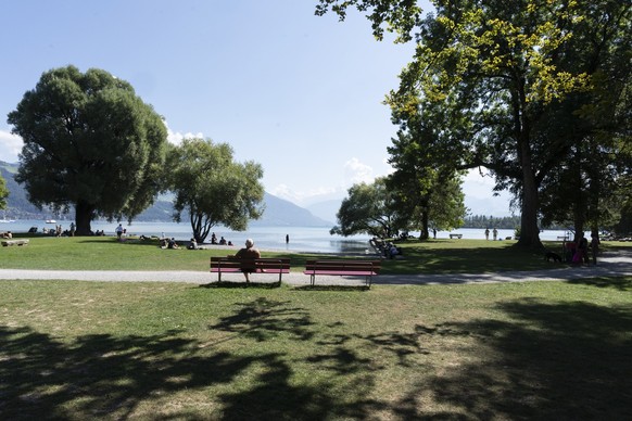 Personen geniessen die Sonne am Thunersee neben dem TCS Campingplatz Gwatt Thunersee, fotografiert am 6. September 2021 in Gwatt, Kanton Bern. (KEYSTONE/Gaetan Bally)