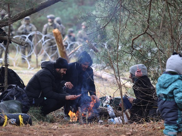 epa09572082 A handout photo made available by Belta news agency shows migrants gathering on the Belarusian-Polish border in the Grodno region, Belarus, 08 November 2021 (issued 09 November 2021). Acco ...