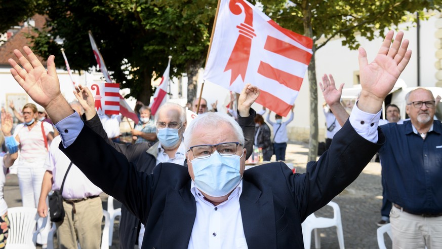 Le maire de la ville de Moutier Marcel Winistoerfer chante la rauracienne en portant un masque de protection et sans se tenir la main lors de la 73eme Fete du peuple jurassien dont le programme a ete  ...