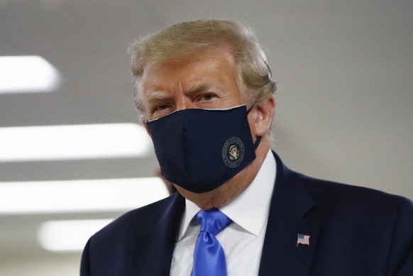 FILE - In this July 11, 2020, file photo President Donald Trump wears a face mask as he walks down a hallway during a visit to Walter Reed National Military Medical Center in Bethesda, Md. On Tuesday, ...