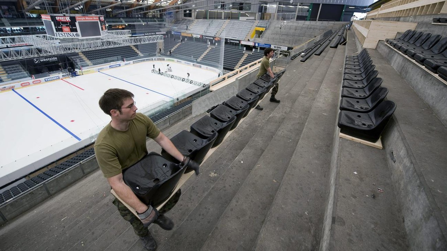 2009 montieren Soldaten Sitze auf der Stehrampe in Bern, um das Stadion für die Eishockey-WM vorzubereiten.