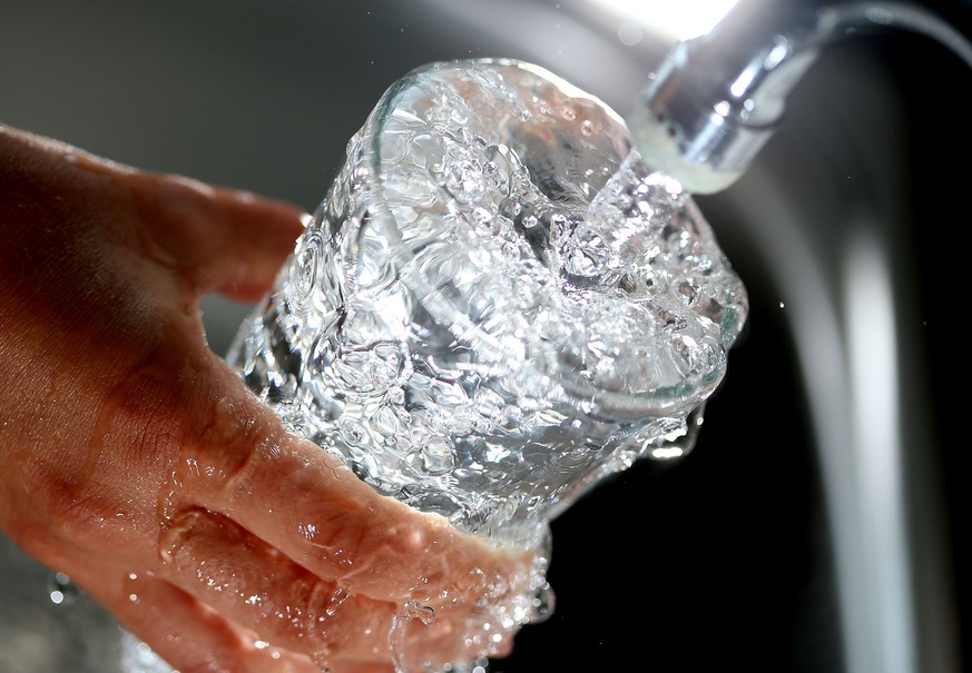 ARCHIV - Trinkwasser läuft aus Wasserhan sprudelnd am 25.07.2013 in Köln in ein Glas. Die Berliner haben in diesem Jahr trotz des regenreichen Sommers bislang kaum weniger Wasser verbraucht. Bis Ende  ...