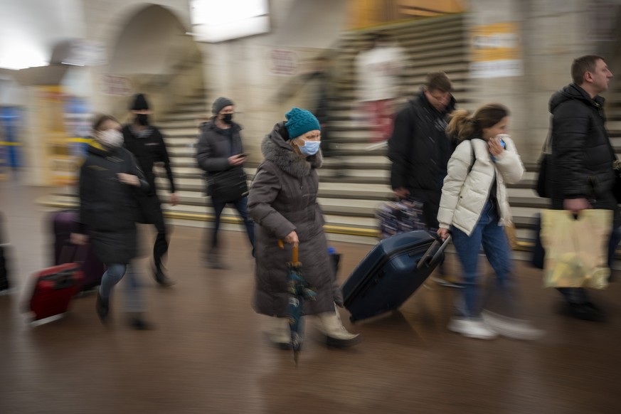 People walk in a subway to get a train as they leave the city of Kyiv, Ukraine, Thursday, Feb. 24, 2022. Russian President Vladimir Putin on Thursday announced a military operation in Ukraine and warn ...