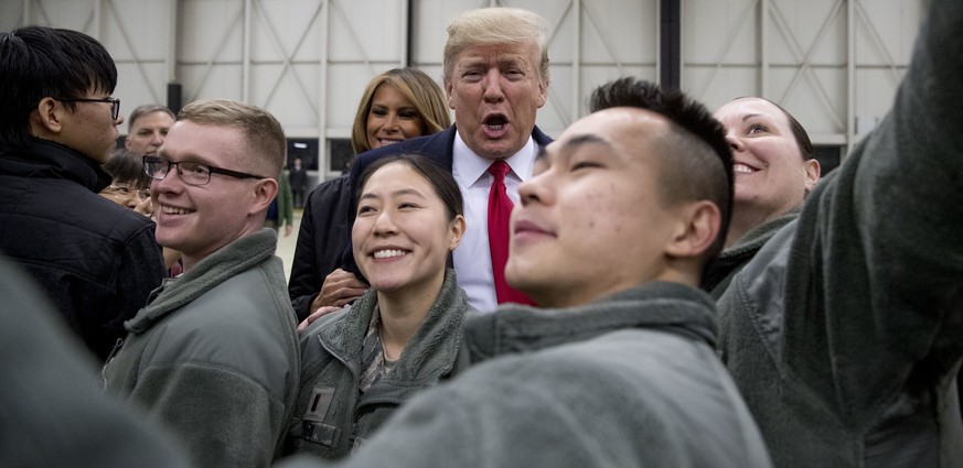 FILE - In this Thursday, Dec. 27, 2018 file photo, President Donald Trump, center, and first lady Melania Trump, center left, greet members of the military at Ramstein Air Base, Germany. Germany&#039; ...