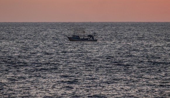 epa09296421 A Palestinian fishing boat sails at sea during sunset in Gaza City, 23 June 2021. EPA/MOHAMMED SABER