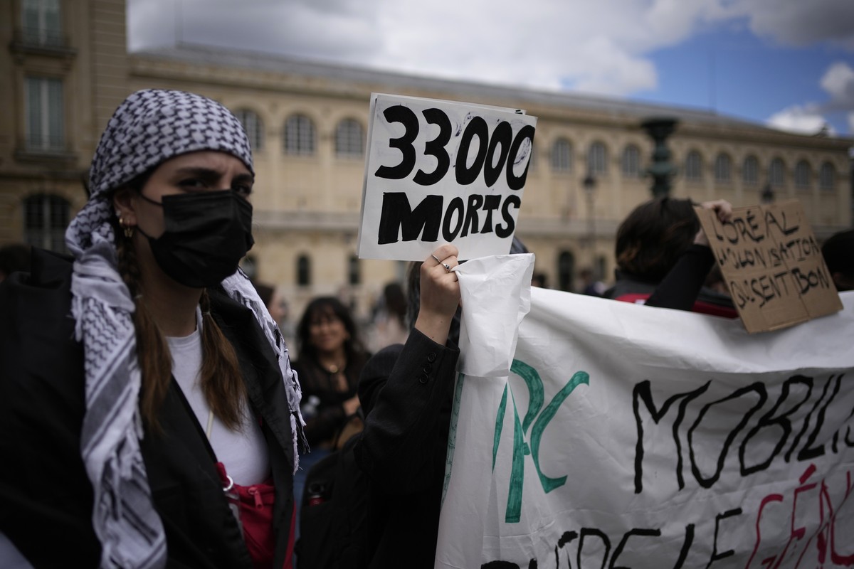 A student holds a poster reading "33 000 dead" during protest near the Pantheon monument Friday, May 3, 2024 in Paris. Students waved Palestinian flags and chanted slogans in support of resi ...