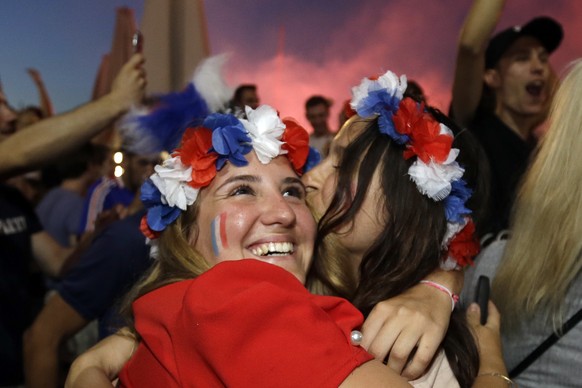 French soccer fans hug each other on the final whistle as they watch a live broadcast of the semifinal match between France and Belgium at the 2018 soccer World Cup, in Marseille, southern France, Tue ...