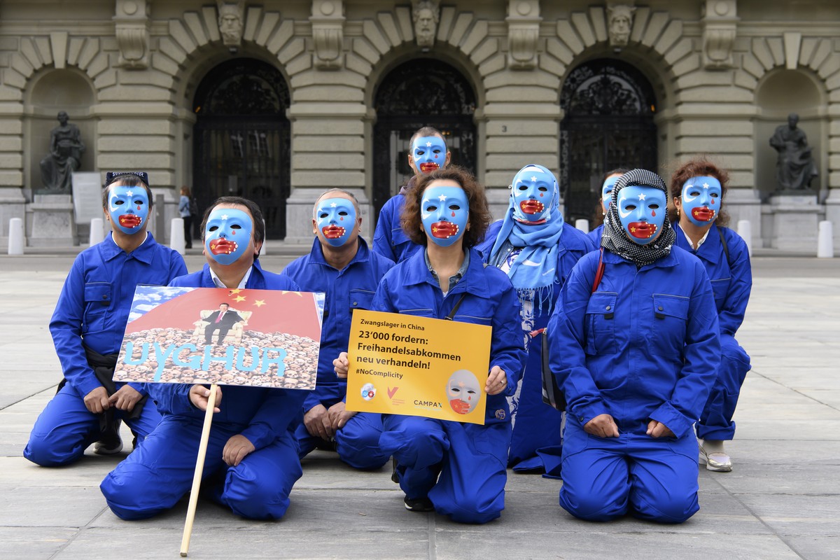 Personen mit Uiguren-Masken posieren auf dem Bundesplatz waehrend der Einreichung der Petition "#NoComplicity: Schweiz muss Freihandelsabkommen mit China neu verhandeln!", am Montag, 7. Sept ...