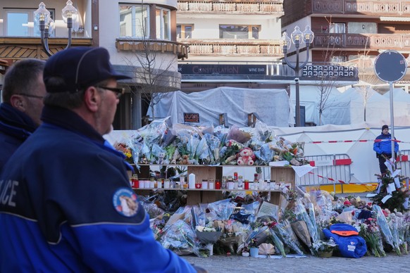 People layed flowers at the sealed off Le Constellation bar in Crans-Montana, Swiss Alps, Switzerland, Saturday, Jan. 3, 2026, where a devastating fire left dead and injured during the New Year's ...