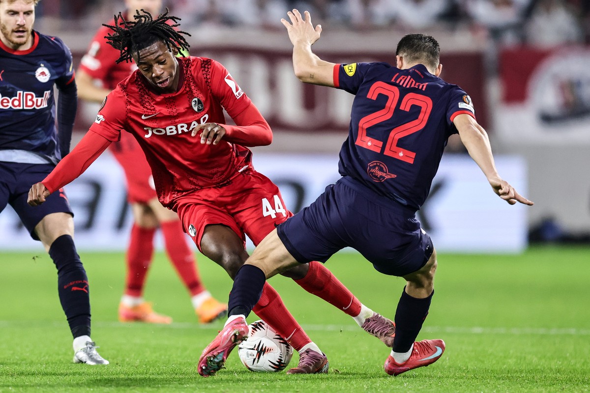 epa12586084 Johan Manzambi (L) of Freiburg and Stefan Lainer of Salzburg in action during the UEFA Europa League match between SC Freiburg and FC Salzburg, in Freiburg, Germany, 11 December 2025. EPA/ ...