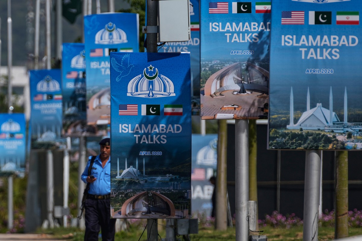A police officer walks past billboards near the Serena Hotel ahead of the second round of negotiations between the U.S. and Iran, in Islamabad, Pakistan, Tuesday, April 21, 2026. (AP Photo/Anjum Navee ...