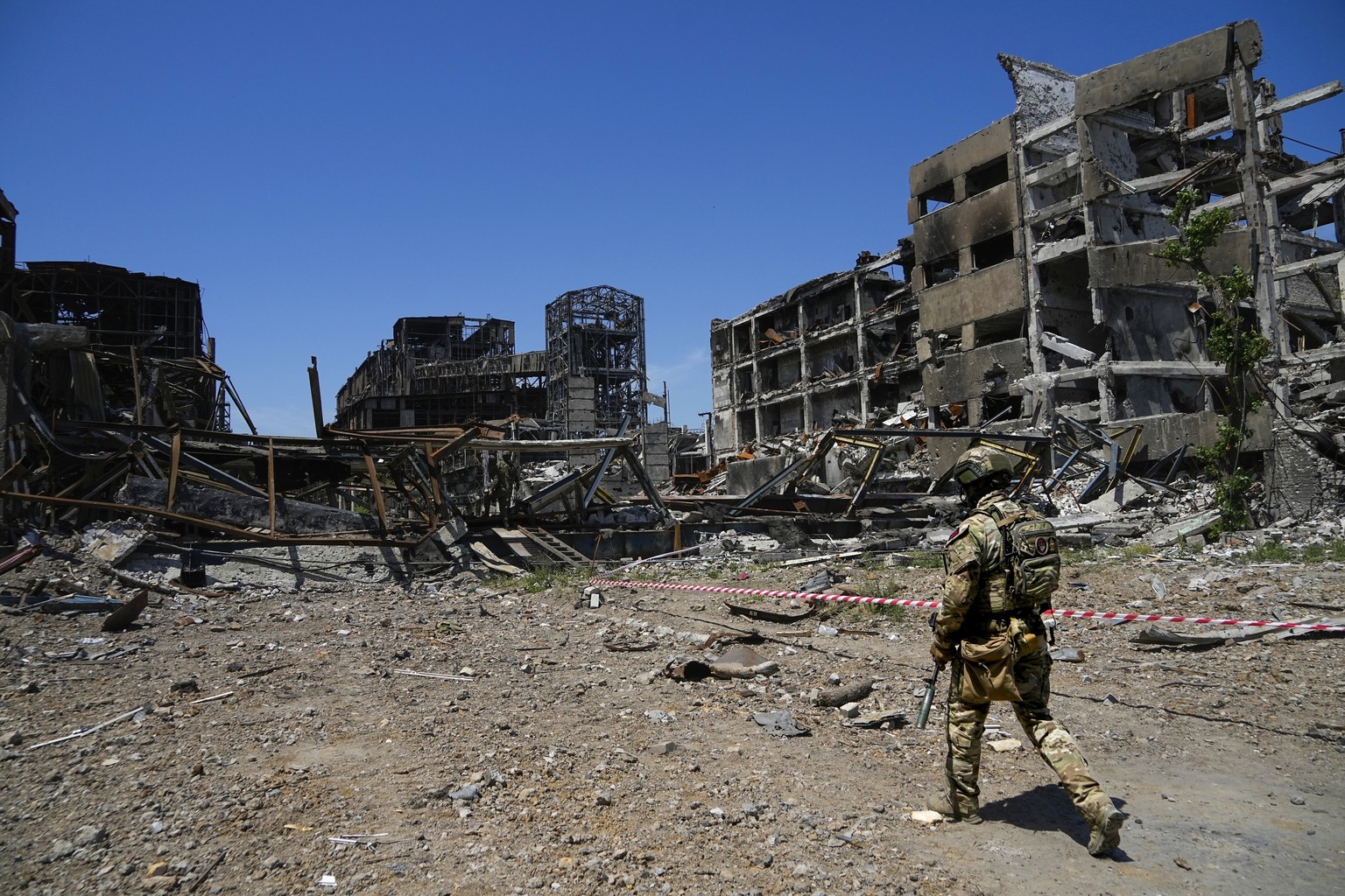 FILE - A Russian soldier walks in front of the damaged Metallurgical Combine Azovstal plant, in Mariupol, on the territory which is under the Government of the Donetsk People&#039;s Republic control,  ...
