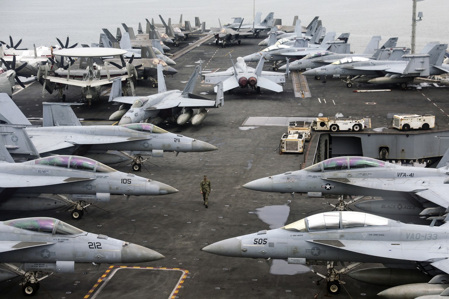 epaselect epa11741236 A US Navy officer walks past fighter jets on the flight deck of the Nimitz-class aircraft carrier USS Abraham Lincoln during a media tour, in Port Klang, outskirts of Kuala Lumpu ...