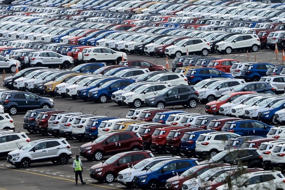 epa09465044 An Indian worker walks near parked Ford cars at the Ford India plant located in Chengalpattu, some 50km south of Chennai, India, 13 September 2021. On 09 September 2021, US carmaker Ford M ...