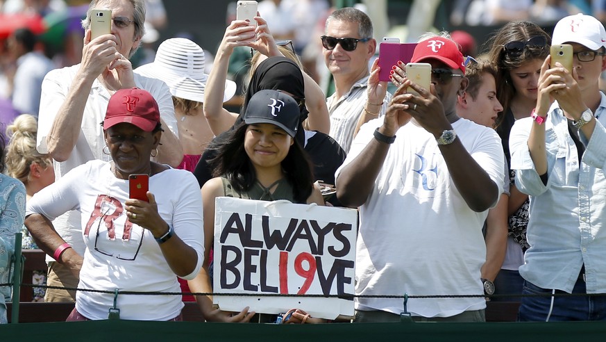 Fans of Roger Federer watch him play during a warm up training session prior to his second round match against Dusan Lajovic of Serbia, at the Wimbledon Championships at the All England Lawn Tennis Cl ...