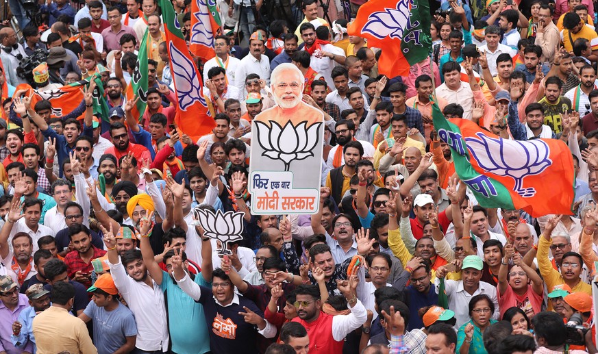 epa07594706 Bharatiya Janata Party (BJP) supporters hold placrds reads in Hindi &#039;one more time Modi government&#039; as they celebrate after the BJP&#039;s potential win in New Delhi, India, 23 M ...