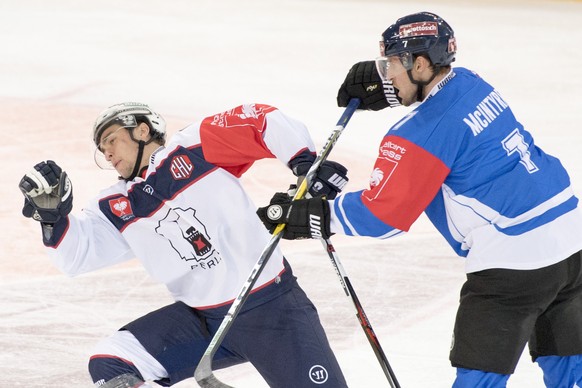 Zug's David McIntyre, right, fights against Berlin's Sven Ziegler, left, during the ice hockey Champions League match 1/16 Final between EHC Zug and Eisbaeren Berlin, in Zug, Switzerland, Tu ...
