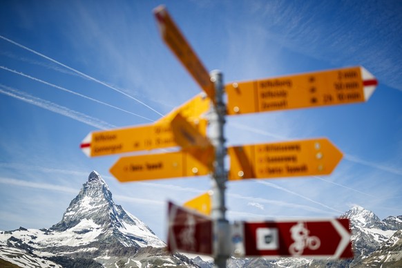 epa06830583 The iconic Matterhorn mountain, peaking at 4478m, is pictured behind hiking direction signs in the Riffelberg area above the alpine village of Zermatt, Switzerland, 22 June 2018. EPA/VALEN ...