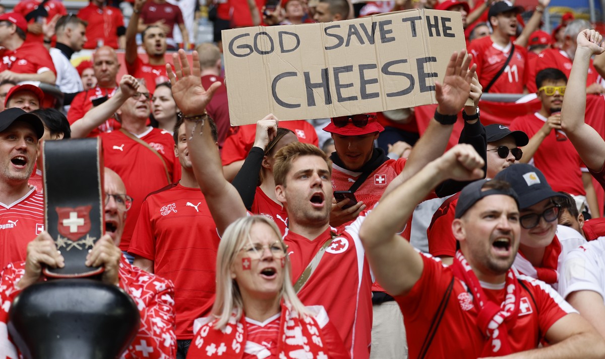 Swiss fans hold a "God save the cheese" banner prior to the quarter final match between England and Switzerland at the Euro 2024 soccer tournament in Duesseldorf, Germany, Saturday, July 6,  ...