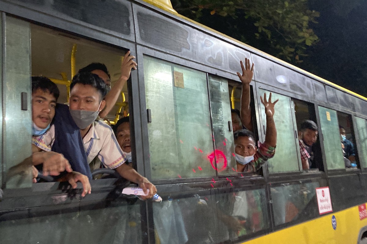 People wave from a bus after being released from Insein Prison in Yangon, Myanmar, Monday, Oct. 18, 2021. Myanmar's government on Monday announced an amnesty for more than 5,600 people arrested f ...