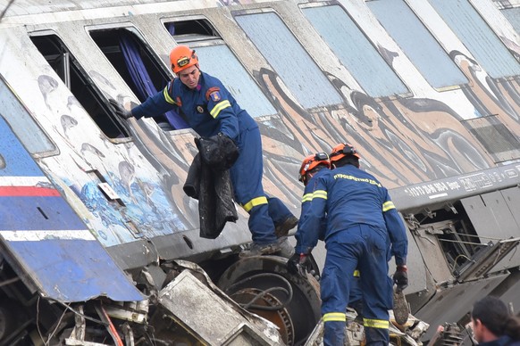 epa10497208 Firefighters and rescue crews work to extricate passengers from trains after a collision near Larissa city, Greece, 01 March 2023. Fire fighter and ambulance service crews remain at the sc ...