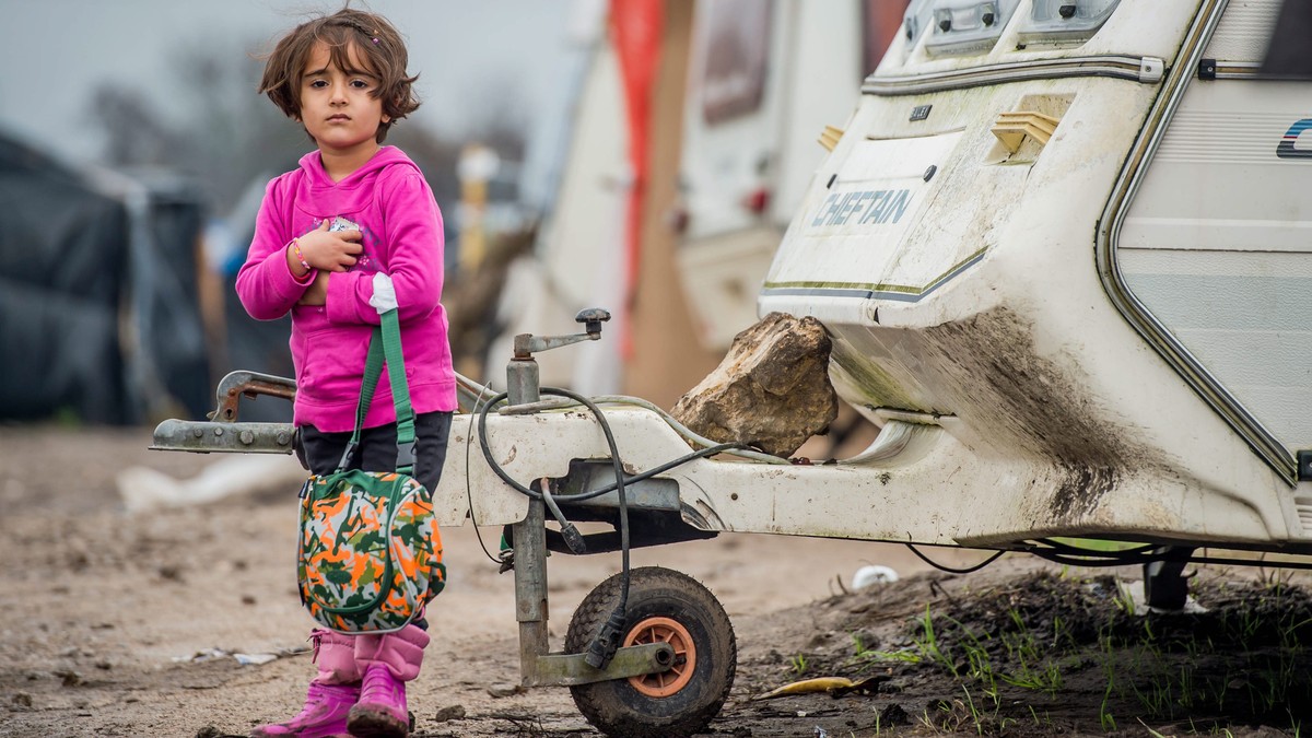 epa05080900 A refugee girl carries a small bag she received as a gift for Christmas in the refugee camp during Christmas Day in the camp called 'The Jungle' in the port of Calais, France, 25 ...