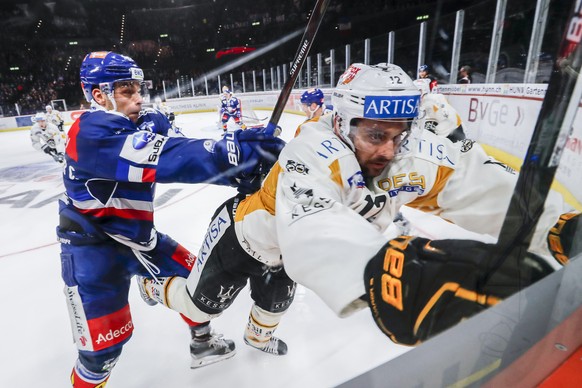 Der Zuercher Chris Baltisberger, links, stoesst Luganos Luca Cunti an die Bande, waehrend dem Eishockey-Meisterschaftsspiel der National League zwischen den ZSC Lions und dem HC Lugano, am Donnerstag, ...