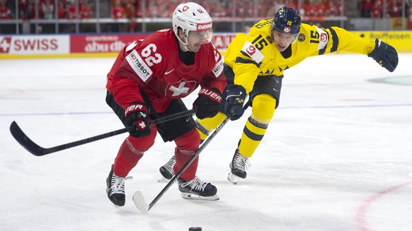 Switzerland's Denis Malgin, left, vies for the puck against Sweden's Jack Berglund during the 2026 IIHF Men's Ice Hockey World Championship Quarterfinal game between Switzerland and Swe ...