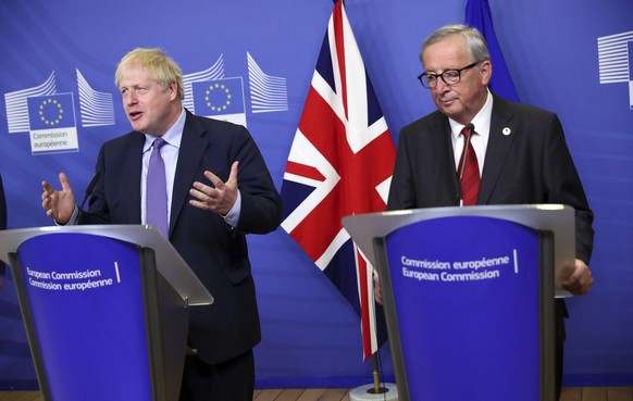 British Prime Minister Boris Johnson and European Commission President Jean-Claude Juncker make prepared statements during a press point at EU headquarters in Brussels, Thursday, Oct. 17, 2019. Britain and the European Union reached a new tentative Brexit deal on Thursday, hoping to finally escape the acrimony, divisions and frustration of their three-year divorce battle. (AP Photo/Francisco Seco)
