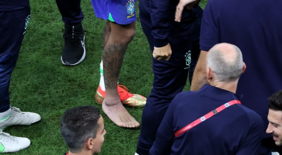 epa10326827 Neymar of Brazil (C) walks with his right boot taken off as he leaves the bench at the end of the FIFA World Cup 2022 group G soccer match between Brazil and Serbia at Lusail Stadium in Lu ...