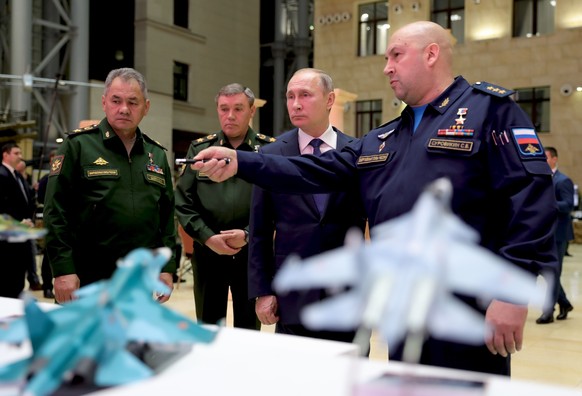 Russian President Vladimir Putin, second right, Russian Defense Minister Sergey Shoigu, left, and Chief of the General Staff of the Russian Armed Forces Valery Gerasimov, second left, listen to Comman ...