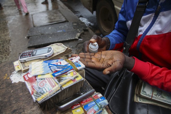 Massnahmen gegen die Ebola-Ausbreitung: Ein Strassenhändler in Monrovia desinfiziert sich die Hände.