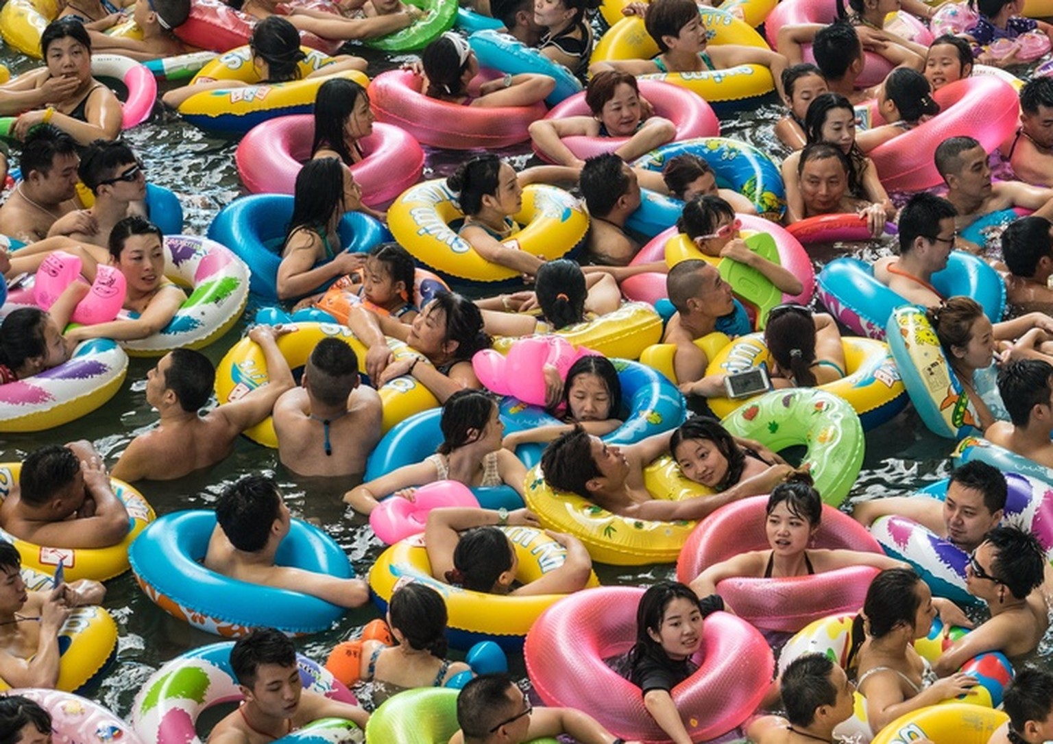 epa06260390 YEARENDER 2017 JULY..Chinese tourists with swim rings enjoy swimming in the lake called 'Dead sea of China' in a resort of Suining city, southwestern China's Sichuan provinc ...