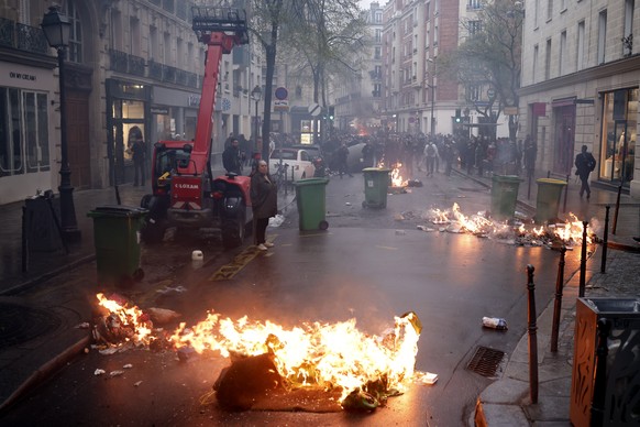 epa10572796 Fires burn during clashes at a rally near the Constitutional Council after the proclamation of their decision about the government&#039;s pension reform text, in Paris, France, 14 April 20 ...