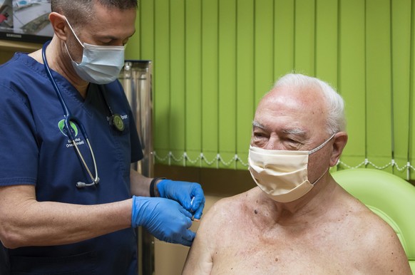 epa08989127 An elderly man receives the COVID-19 vaccine manufactured by the US biotechnology company Moderna in the surgery of general practitioner Gabor Gulyas in Nyiregyhaza, Hungary, 05 February 2 ...