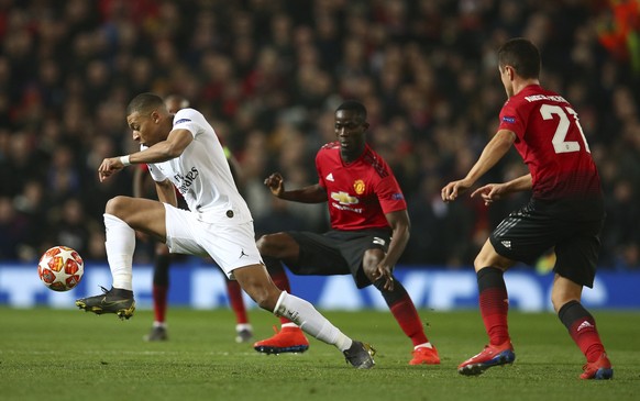 Paris Saint Germain's Kylian Mbappe, left controls the ball as Manchester United's Ander Herrera, right, looks on during the Champions League round of 16 soccer match between Manchester United and Paris Saint Germain at Old Trafford stadium in Manchester, England, Tuesday, Feb. 12, 2019. (AP Photo/Dave Thompson)