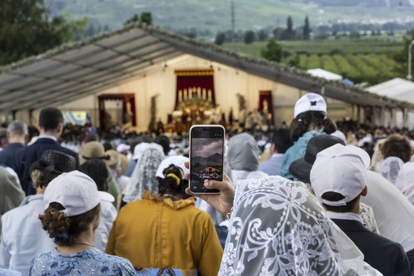 epa13077533 A worshipper photographs with a smartphone the episcopal consecration of Catholic priests during a pontifical mass organized by the Society of Saint Pius X (SSPX), in Econe near Sion, Swit ...