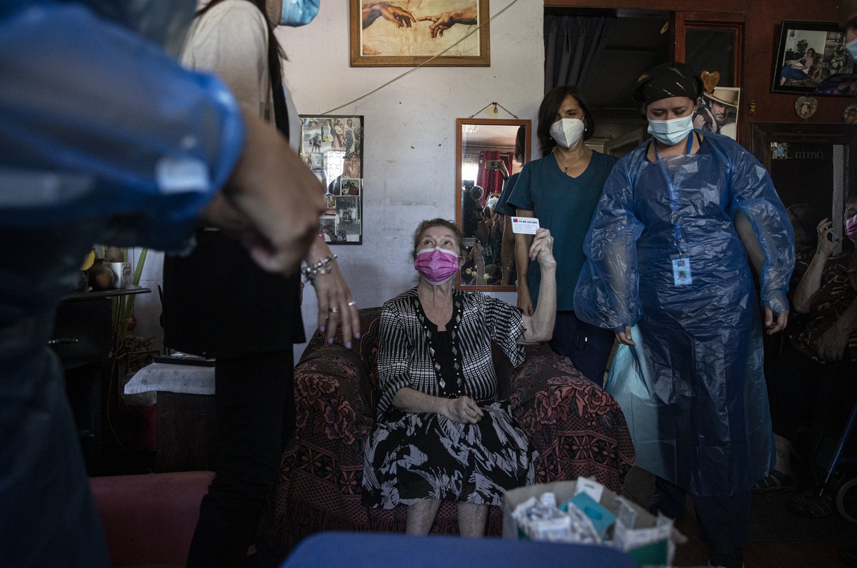Filomena Zuleta, 70, holds up her vaccination card after she was injected with a dose of China's Sinovac Biotech COVID-19 vaccine, in her family's home in Santiago, Chile, Thursday, Feb. 25, ...
