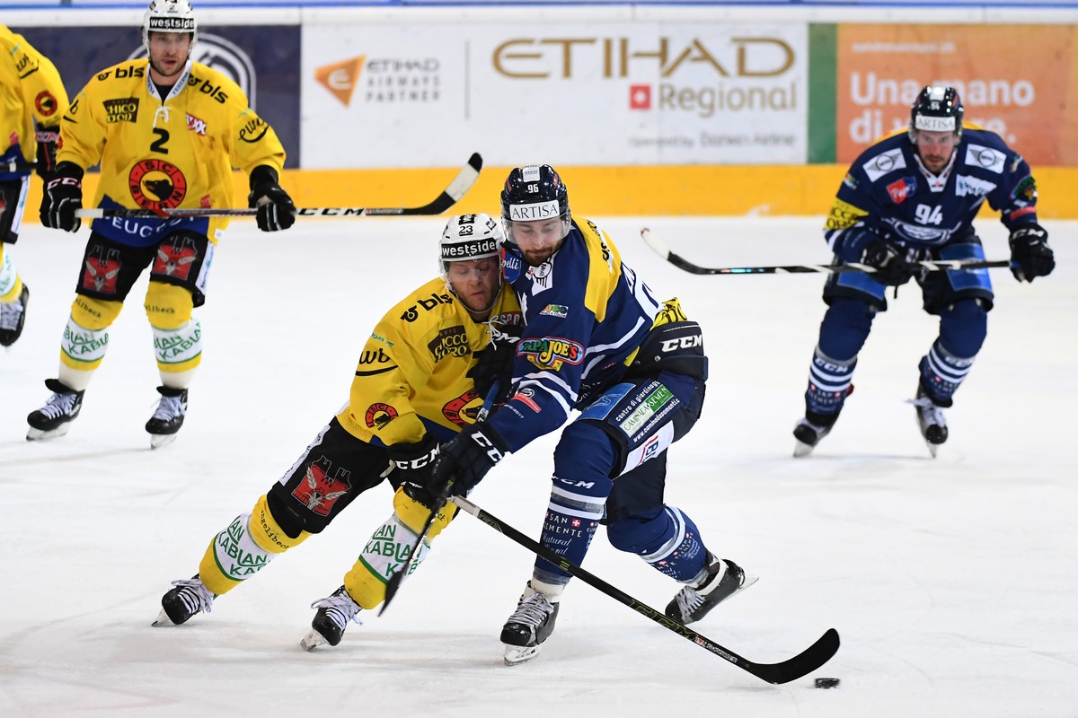 Bern's Simon Bodenmann, left, fights for the puck with Ambri's Adrien Lauper, right, during the preliminary round game of National League A (NLA) Swiss Championship 2016/17 between HC Ambri  ...