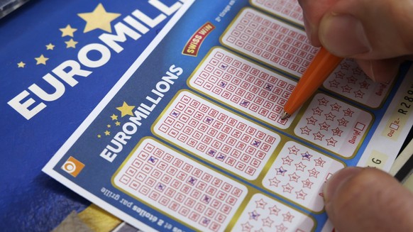 Un homme coche des numeros sur des bulletins de l&#039; Euro Millions de la Loterie Romande dans le kiosque de Josephine, ce lundi 16 octobre 2023 a Cheseaux-sur-Lausanne pres de Lausanne. (KEYSTONE/S ...