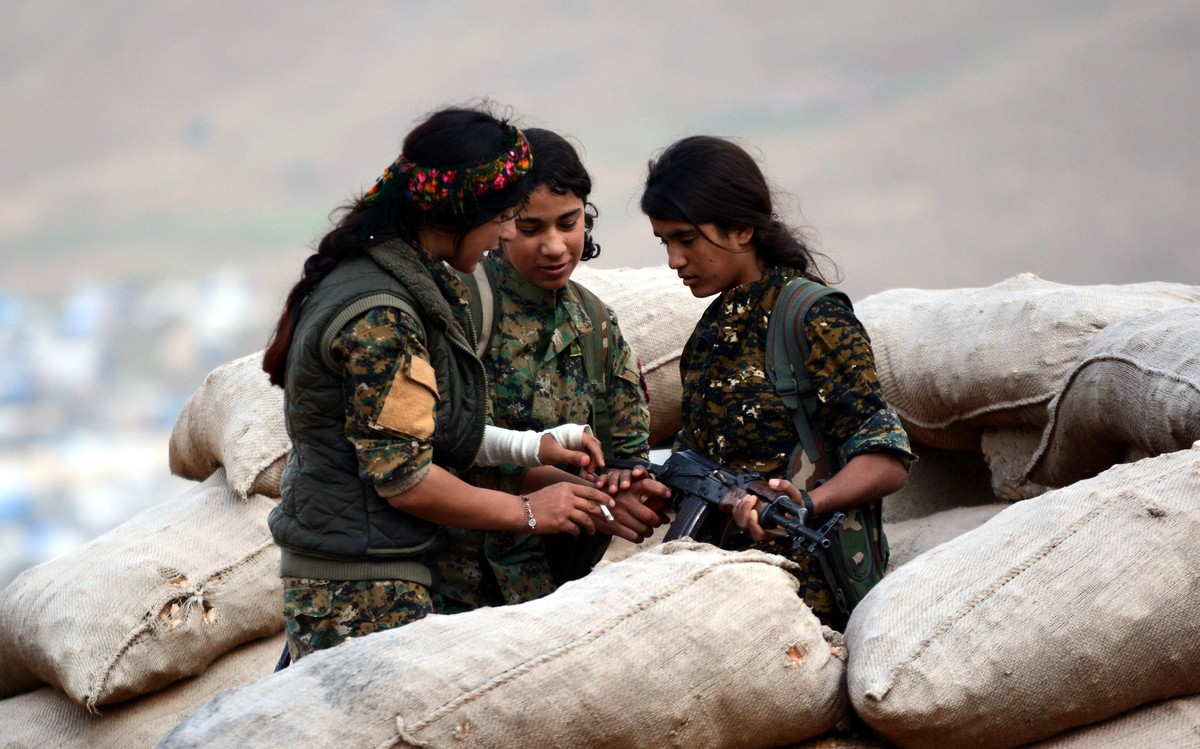 epa06664477 Syrian and Iraqi Kurdish female fighters of the Women's Protection Units (YPJ) and Rojava Defence Units take up position at a military barracks near the northern Iraqi town of Sinjar, ...