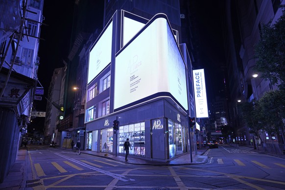 People walk on a quiet street usually packed with shoppers in Causeway Bay, a famous shopping district in Hong Kong Thursday, March 10, 2022. Hong Kong&#039;s neon lights are still on, but COVID-19 ha ...