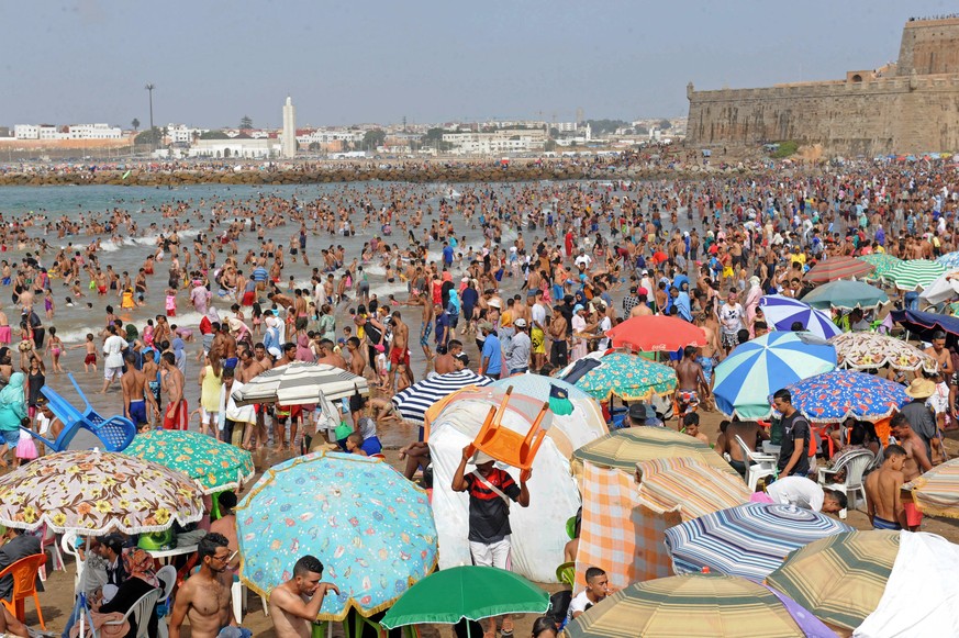 epa06105954 A crowd of people pack the beach in Rabat, Morocco, July 23, 2017. Moroccans and tourists took advantage of beautiful summer weather to enjoy the beach. Morocco welcomed about 3 million to ...